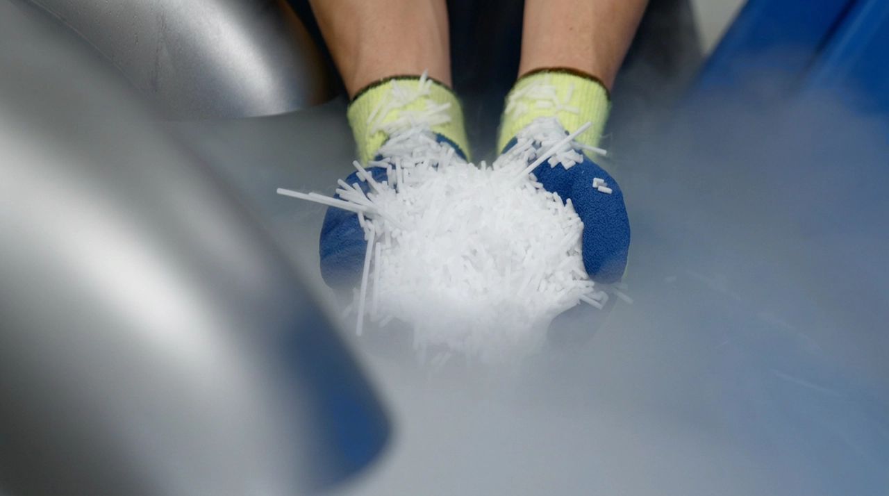 Pellets de gelo seco acabados de extrudir a sair de uma peletizadora Cold Jet